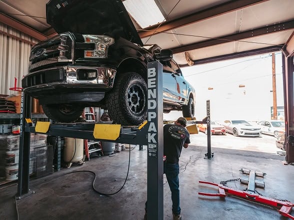Black Market Racing lifted truck in auto repair shop for maintenance.