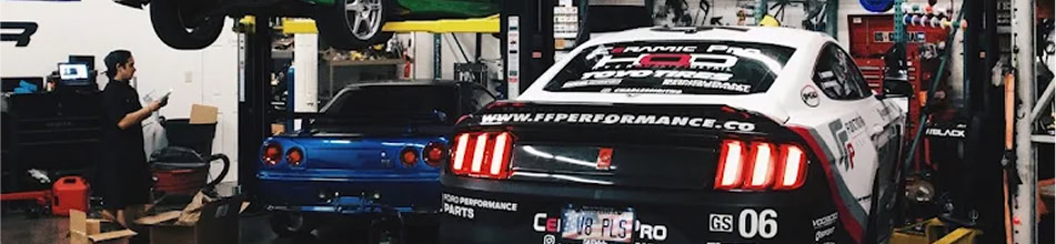Black Market Racing cars in garage with tools and equipment.