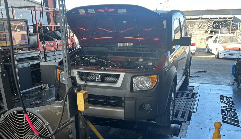 Honda Element with open hood at Black Market Racing workshop.