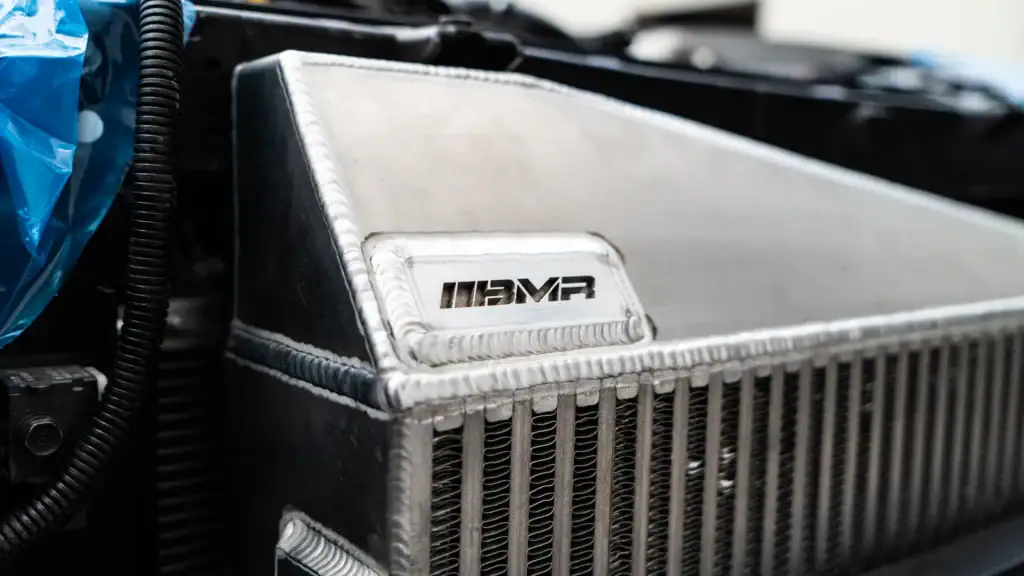 Close-up of custom fabricated aluminum engine component at Black Market Racing.