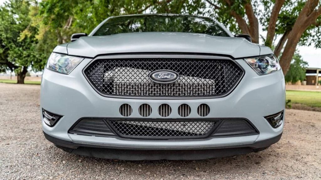 Front grille of a matte grey Ford Taurus SHO with the intercooler visible behind the bumper