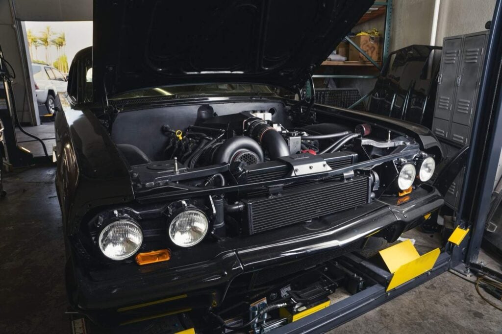 ProCharger centrifugal supercharger and front-mount intercooler in a black Chevrolet on the lift at Black Market Racing